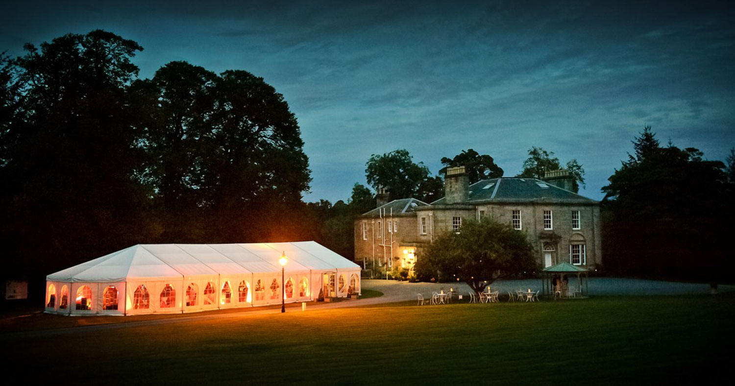 Glencorse House Wedding Venue with the marquee illuminated in the evening light