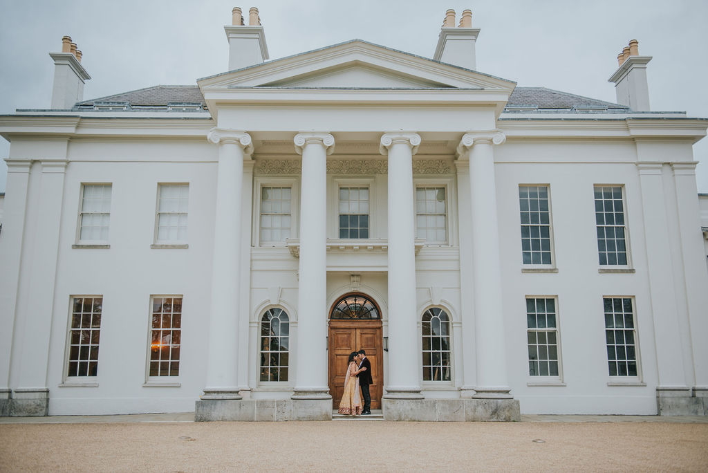 Couple Embracing In Front Of Georgian Wedding Venue