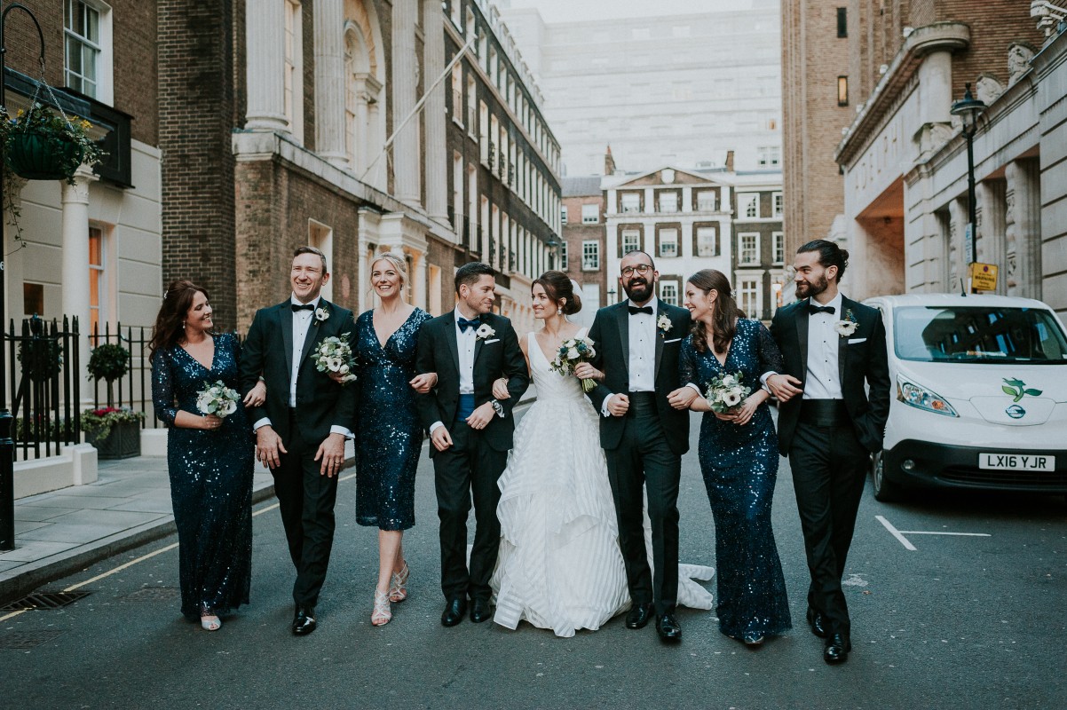 Bride, Groom and bridal party standing on an urban street